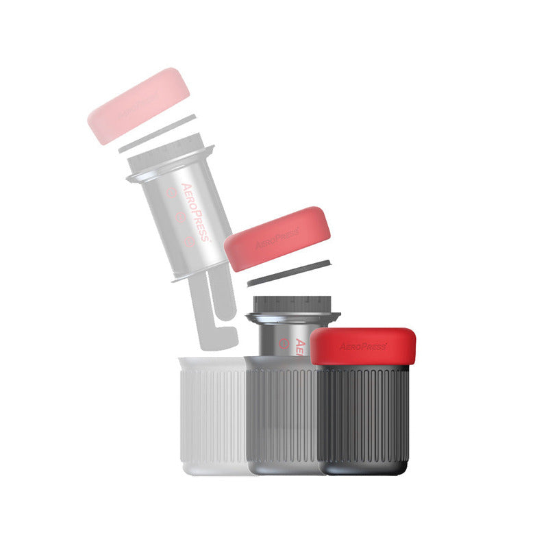Exploded view of AeroPress Go showing how components nest inside the mug with red lid on top.