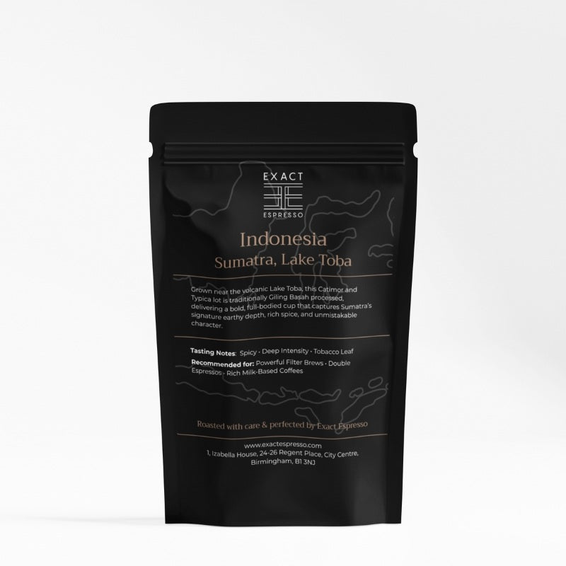 Black coffee bag labeled "Indonesia Sumatra, Lake Toba" featuring premium coffee blend details in white and bronze text.