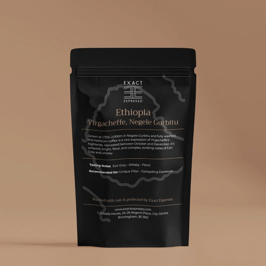 black Ethiopia Yirgacheffe coffee bag, photographed on a soft brown background