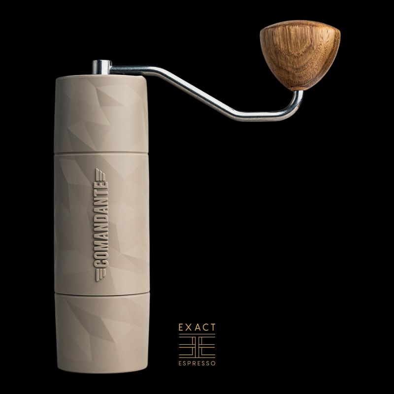 Comandante X25 manual grinder in beige with wooden knob shown on black background.