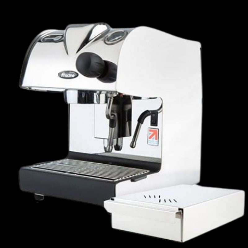 Compact chrome espresso machine with dual spouts, steam wand, and a separate knockout drawer, shown against a black background.